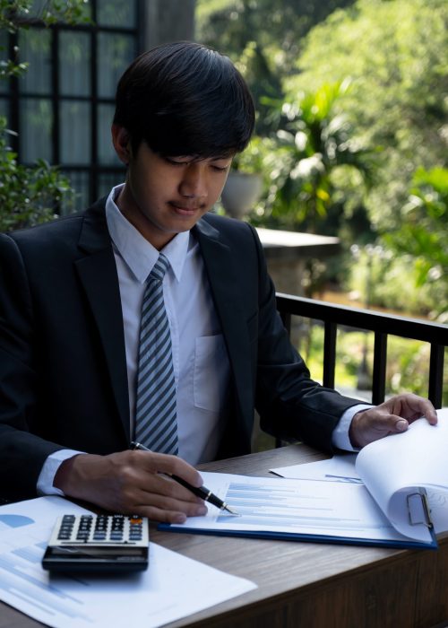 Businessmen bookkeeper holding pen use calculator and laptop analysis the graph for Setting challenging business goals and ready to achieve target at home office.